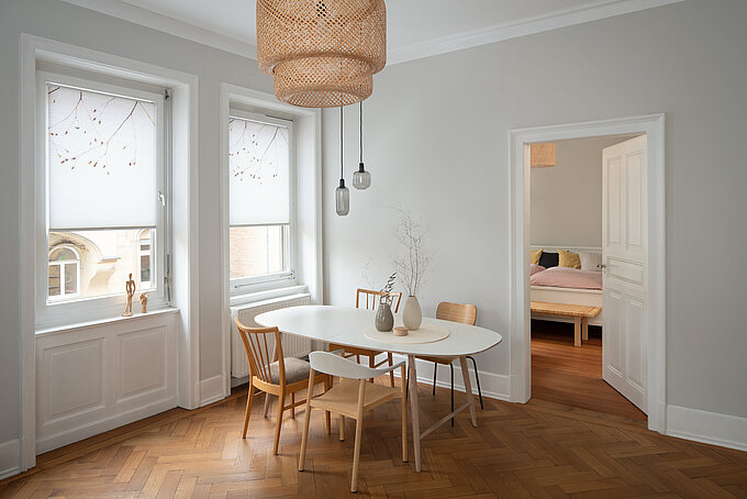 Esszimmer mit zwei Fenstern und weissen Wabenplissees mit zartem Naturmotiv, modern und hell eingerichtet