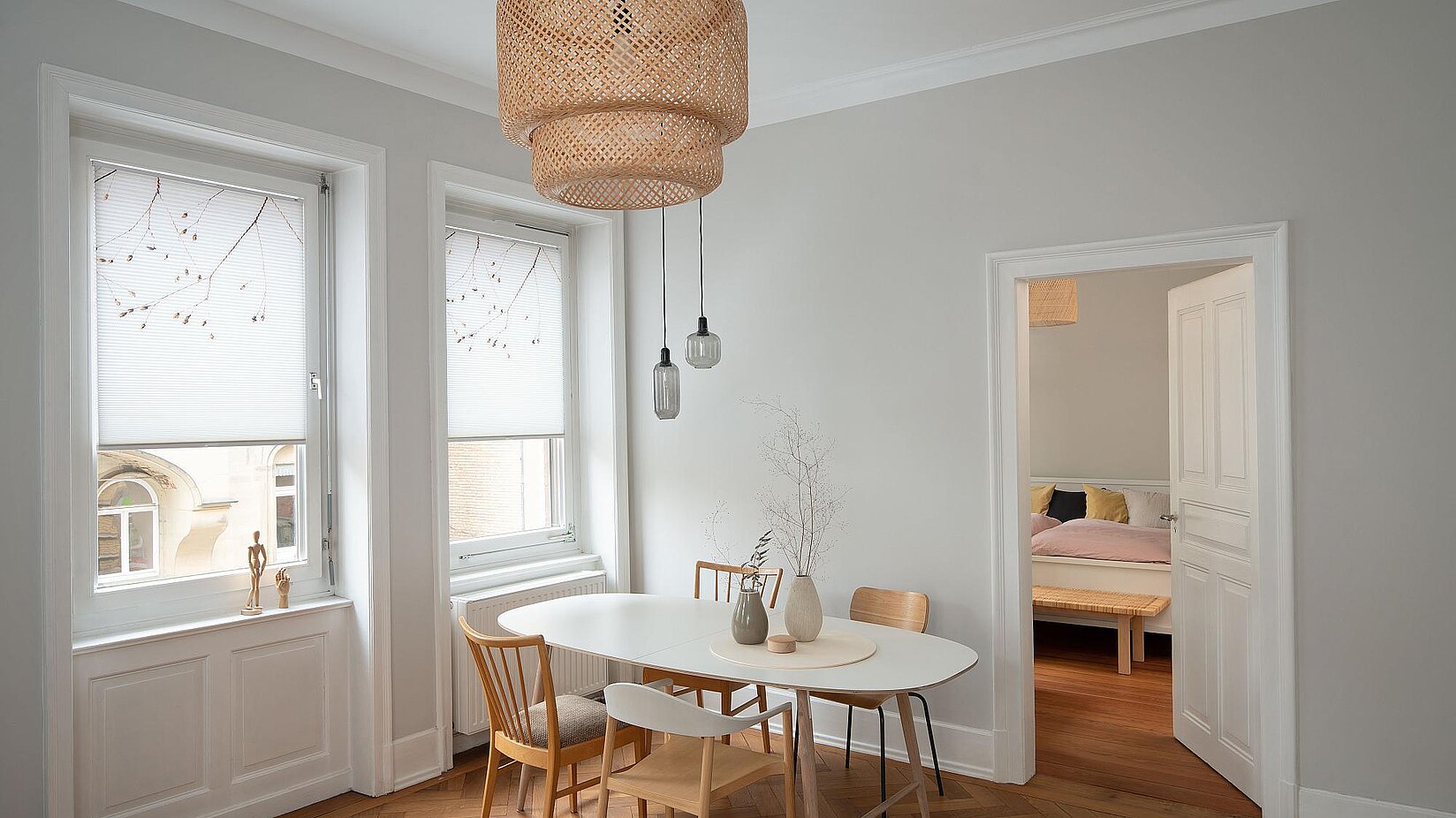 Esszimmer im Altbau mit weissen Holzfenstern und halbtransparenten Wabenplissees mit dezentem Muster für Sicht- und Lichtschutz