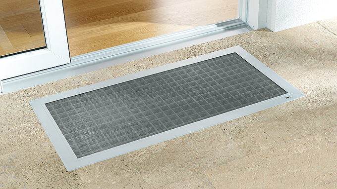 Flächenbündige Insektenschutz-Lichtschachtabdeckung vor bodentiefer Tür installiert.