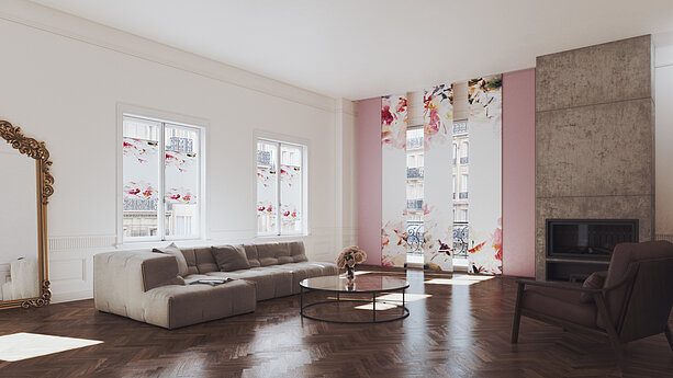 Wohnzimmer mit floralen Plissees und Flächenvorhängen der Kollektion Blossom, zarte Blütenmotive in Rosatönen vor grossen Fenstern