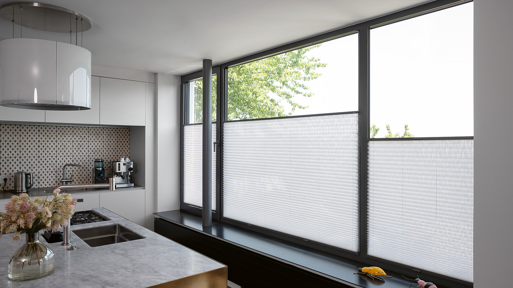 Weisse Plissees im unteren Fensterbereich in moderner Kßche mit grossen Fensterflächen.